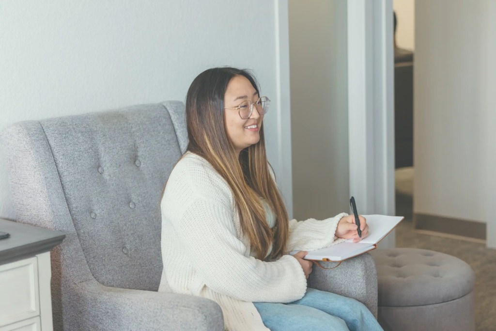 adoption therapist sitting on couch taking notes
